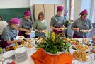 Gruppe von fünf Frauen probiert Speisen am Buffet.