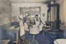 Historisches Bild einer alten Waschküche, in der vier Frauen arbeiten.