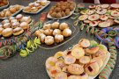 Viele Teller mit süßem und herzhaftem Gebäck, dazwischen dekorative Luftschlangen.