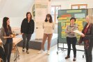 Fünf Frauen stehen im lockeren Halbkreis einander zugewandt da und unterhalten sich.