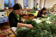 Studierenden stellen Adventskränze her.