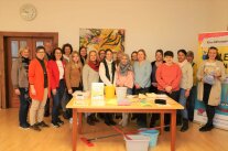 Gruppe von Seminarteilnehmern, davor Tisch