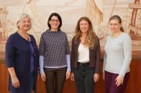 Vier Frauen vor landwirtschaftlichem Motiv in Saal.