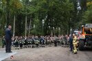 Versammelte schar von Feuerwehrleuten im großen Halbkreis, davor Mann auf einer Hebebühne stehend.