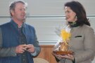Mann und Frau stehen sich gegenüber, Frau hält verpacktes Präsent in den Händen.