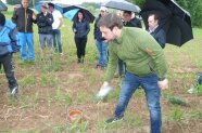 Landwirt vor Zuhörergruppe auf Acker.