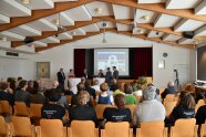Gäste im Festsaal und Redner am Pult.