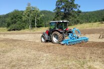 Traktor mit landwirtschaftlichen Gerät bei Bodenbearbeitung