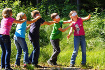 Fünf Kinder mit verbundenen Augen bilden eine Schlange © Jonas Eckle